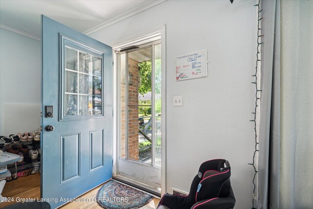 doorway to outside featuring ornamental molding and hardwood / wood-style flooring