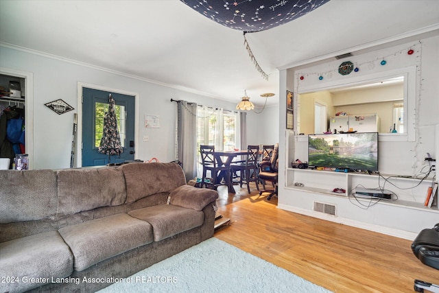 living room featuring wood-type flooring and crown molding