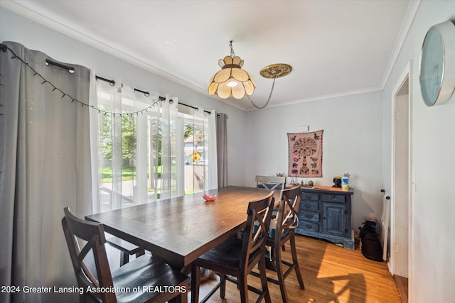 dining space with light wood-type flooring and crown molding