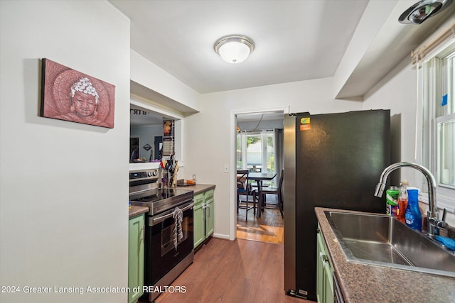 kitchen with green cabinetry, sink, dark wood-type flooring, and stainless steel appliances