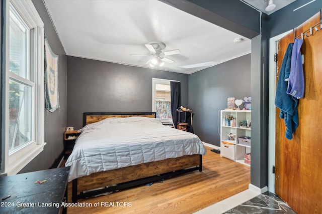 bedroom with ceiling fan, crown molding, and hardwood / wood-style floors