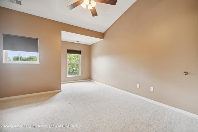 carpeted empty room featuring ceiling fan and lofted ceiling