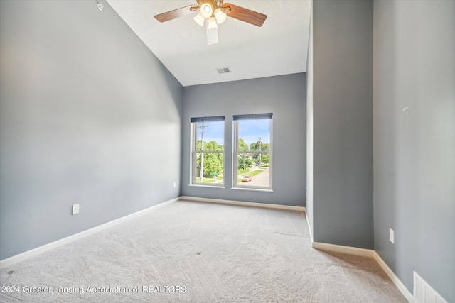 carpeted empty room featuring ceiling fan and lofted ceiling