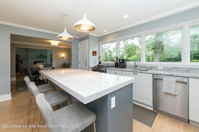 kitchen featuring appliances with stainless steel finishes, plenty of natural light, sink, and hanging light fixtures