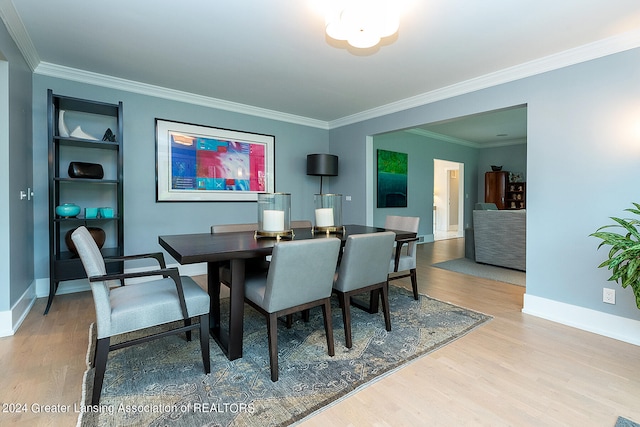 dining area with ornamental molding and light wood-type flooring