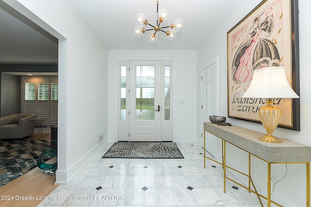 foyer entrance featuring plenty of natural light and a notable chandelier