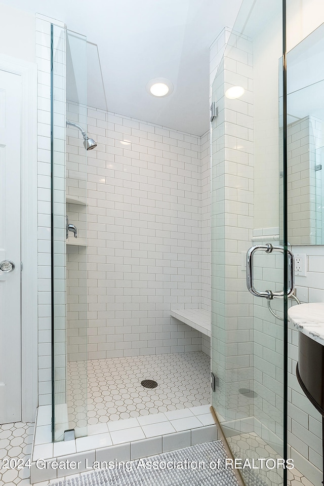 bathroom featuring tile patterned floors, an enclosed shower, and vanity