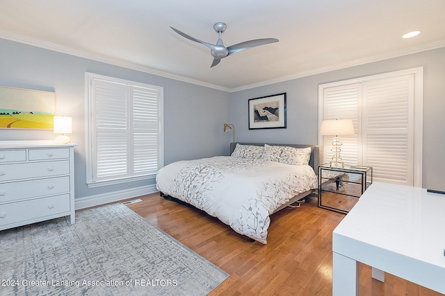 bedroom featuring crown molding, light hardwood / wood-style flooring, and ceiling fan