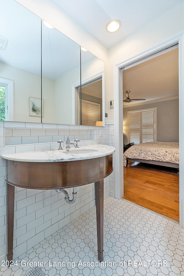 bathroom featuring backsplash, sink, and ceiling fan