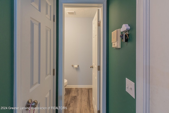 corridor featuring hardwood / wood-style floors and a textured ceiling