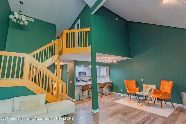 interior space featuring a high ceiling, an inviting chandelier, and hardwood / wood-style flooring