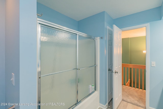 bathroom with bath / shower combo with glass door