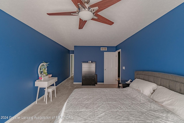 unfurnished bedroom with ceiling fan, a textured ceiling, and light carpet