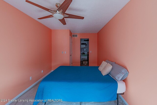 bedroom featuring a textured ceiling, carpet floors, and ceiling fan