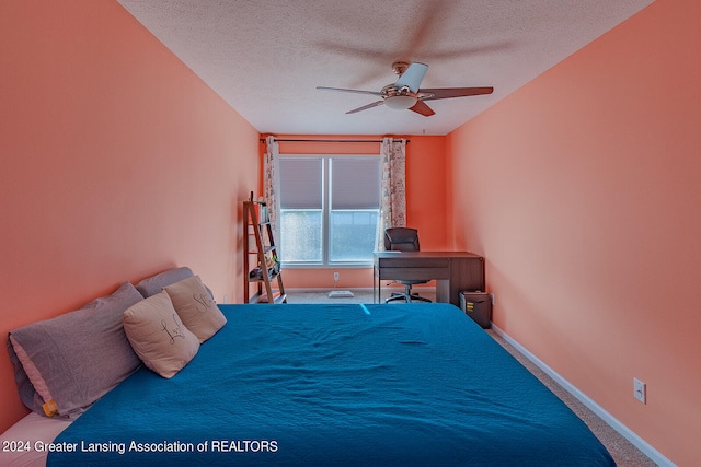 bedroom featuring ceiling fan, a textured ceiling, and carpet floors