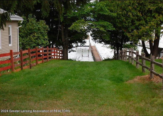 view of yard with a dock and fence