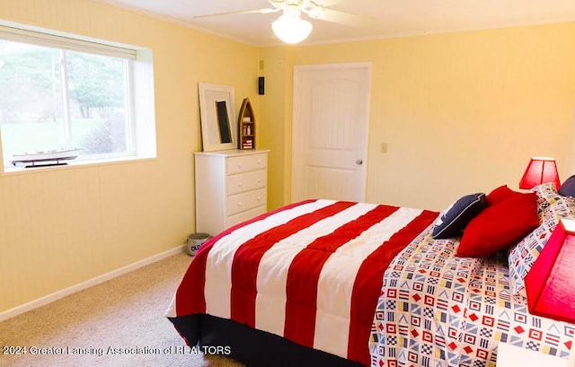 carpeted bedroom with a ceiling fan, crown molding, and baseboards