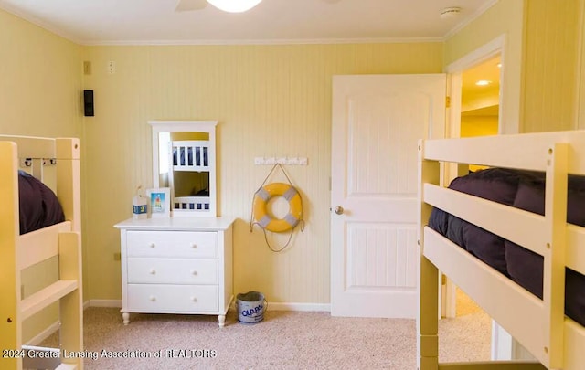 carpeted bedroom with ornamental molding and baseboards