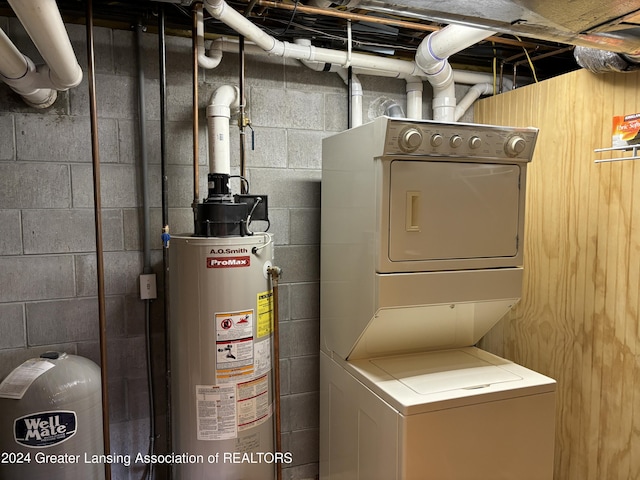 utility room with stacked washer / drying machine and gas water heater