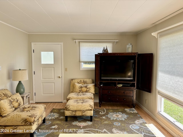 living area featuring ornamental molding, wood finished floors, and baseboards