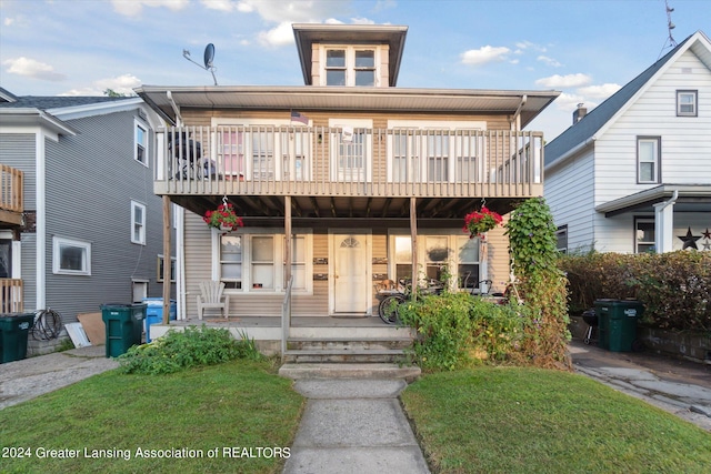 view of front of home featuring a balcony and a front yard