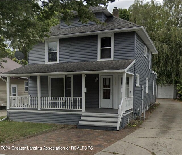 view of front of house featuring a garage, a porch, and an outbuilding