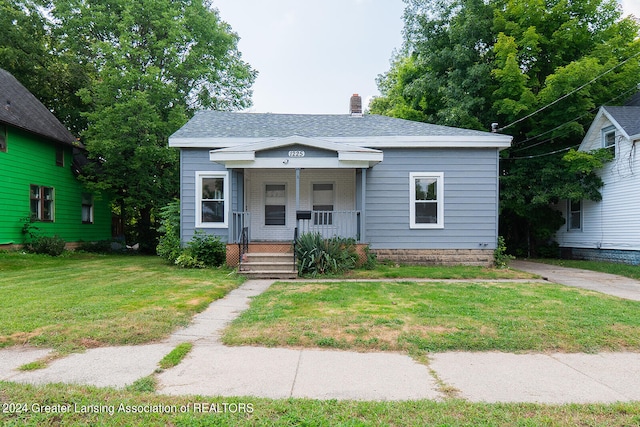 bungalow-style home with a front yard and covered porch