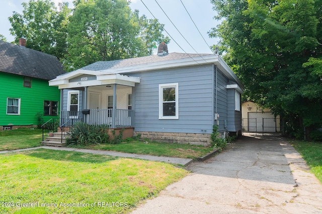 bungalow-style house featuring a porch, a chimney, and a front yard