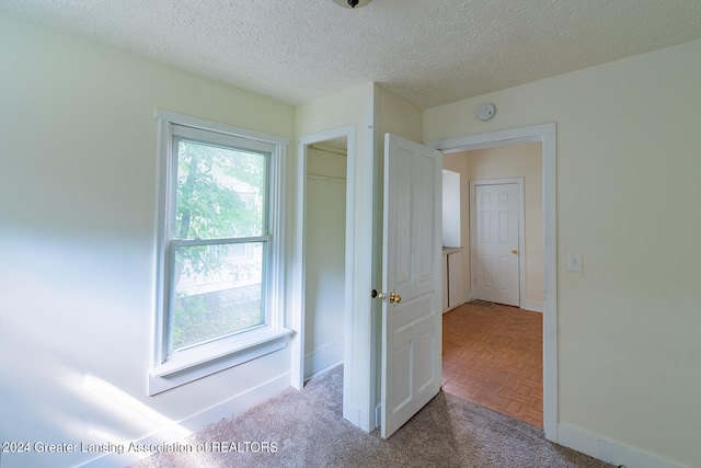 empty room with a textured ceiling and parquet floors