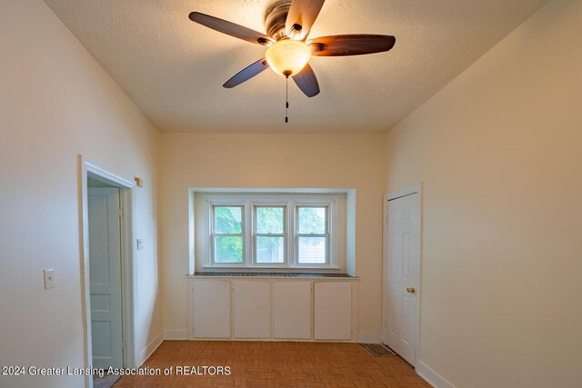 interior space with a textured ceiling and light parquet flooring