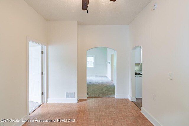 hallway featuring light parquet flooring and a textured ceiling