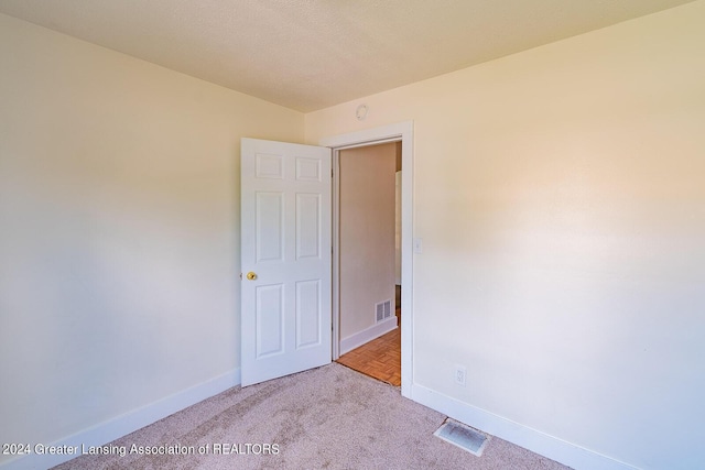 empty room featuring carpet, baseboards, and visible vents