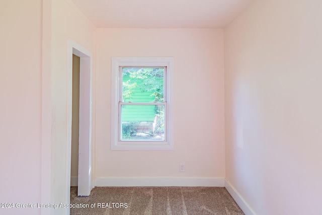 empty room featuring baseboards and carpet flooring