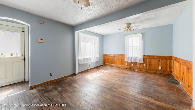 spare room featuring a textured ceiling, a wealth of natural light, ceiling fan, and dark hardwood / wood-style floors