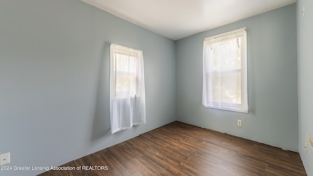 unfurnished room with dark hardwood / wood-style flooring