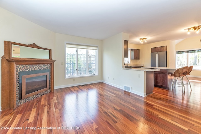 unfurnished living room featuring a fireplace, plenty of natural light, and dark hardwood / wood-style flooring