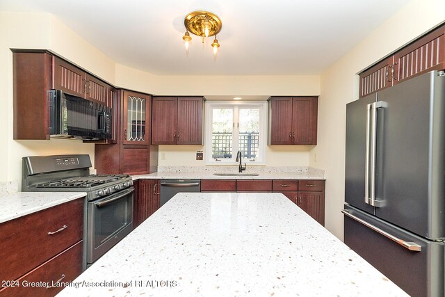 8425 Oakside St, Portage, MI 49002 - kitchen with stainless steel appliances, a sink, light stone counters, and glass insert cabinets