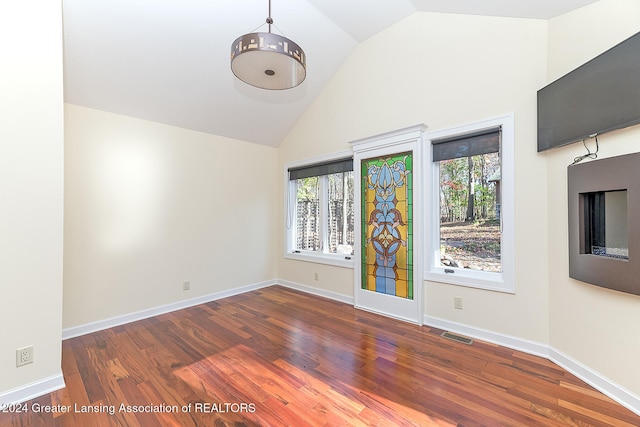 spare room with dark hardwood / wood-style flooring and vaulted ceiling