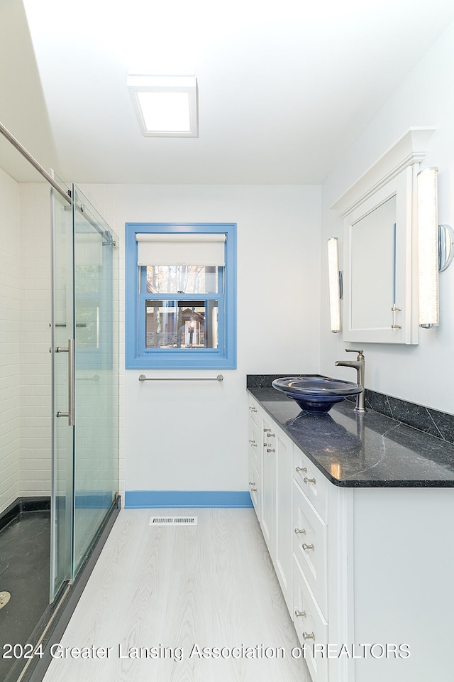 bathroom with vanity, an enclosed shower, and wood-type flooring