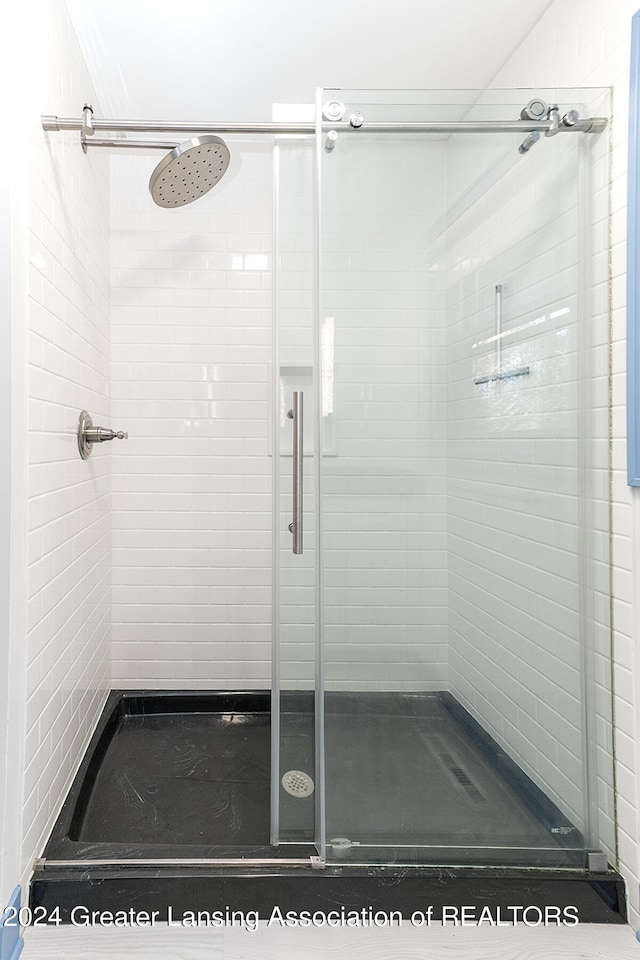 bathroom with a shower with door