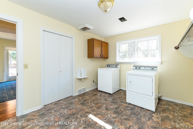 laundry area featuring washer and clothes dryer, cabinets, and dark hardwood / wood-style floors