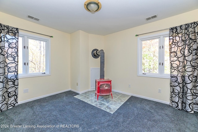 interior space with a wood stove and carpet flooring