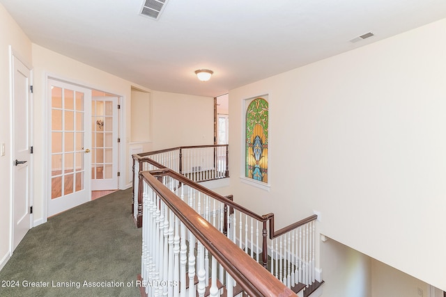 corridor featuring french doors and dark carpet