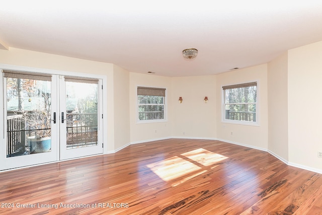 empty room with french doors and hardwood / wood-style flooring