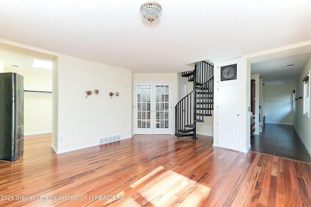 spare room featuring french doors and hardwood / wood-style flooring