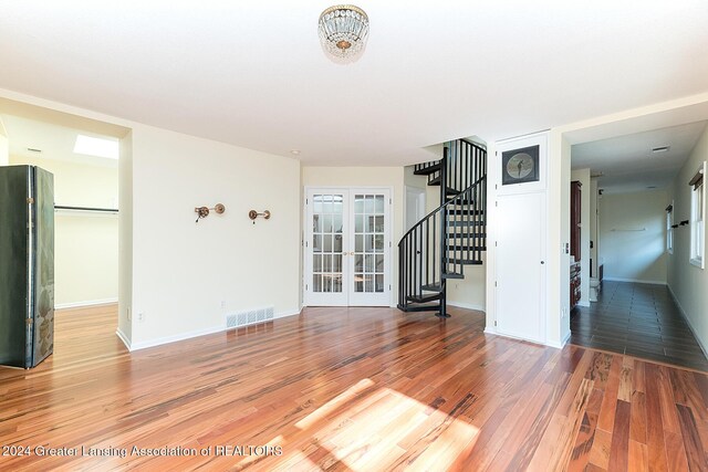8425 Oakside St, Portage, MI 49002 - unfurnished living room with stairway, french doors, light wood-type flooring, and baseboards