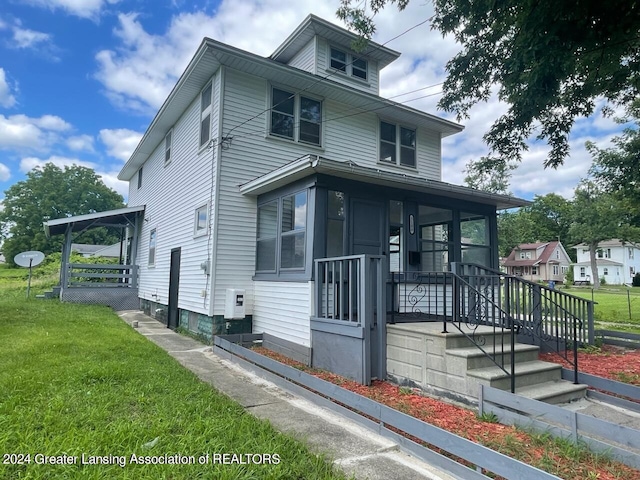 american foursquare style home with covered porch and a front yard