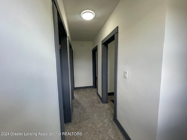 hallway with carpet and baseboards