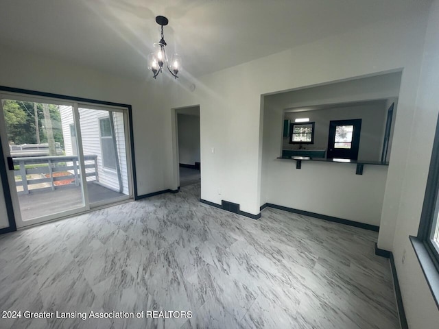 interior space with marble finish floor, baseboards, and a chandelier