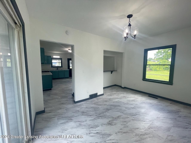 unfurnished room with marble finish floor, visible vents, baseboards, and an inviting chandelier